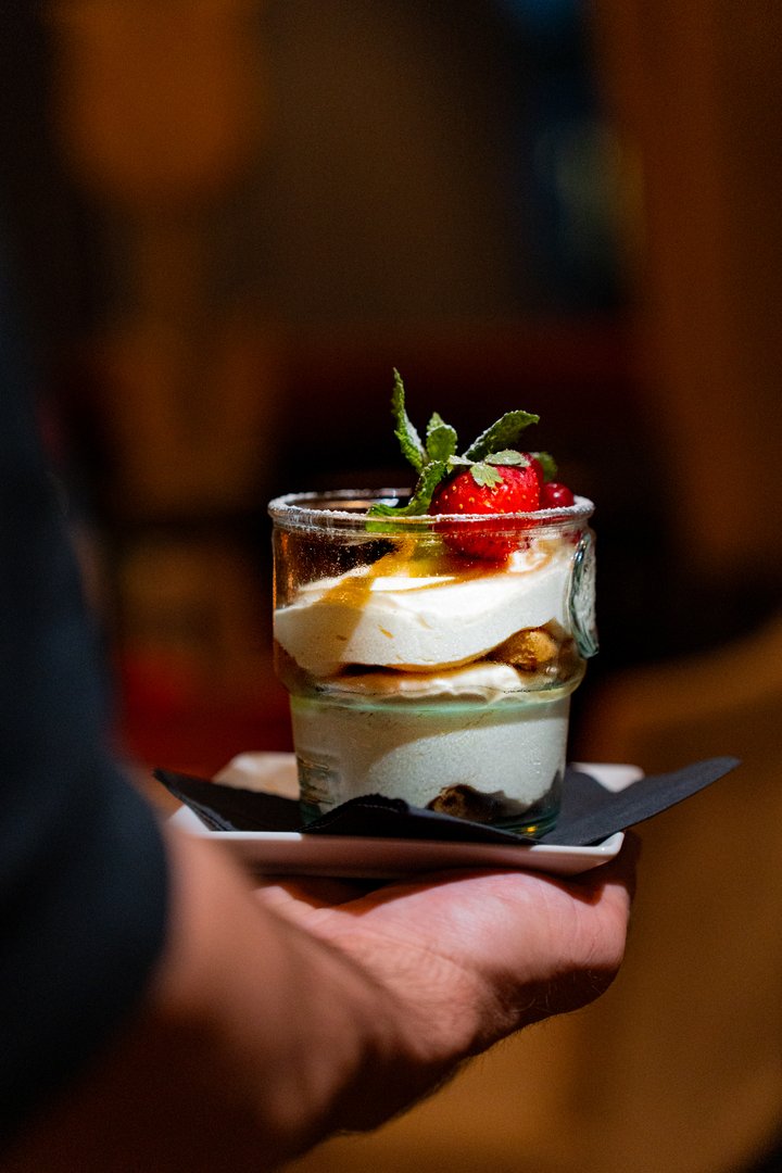 Layered dessert in glass jar with strawberry and mint